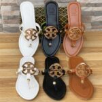 Tory Burch classic flat shoes in white, brown, and black with logo detail.