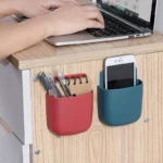 "Wall-mounted phone and remote holder storage box for smartphones, remote controls, and accessories"