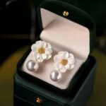 Elegant floral pearl earrings with white petals and golden center, perfect for classy looks.