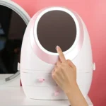 Rechargeable makeup mirror with a dimming LED light ring, sitting on a round cosmetic storage box base, showing its spin or rotating function for a portable vanity setup.