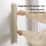 Flexible silicone sink baffle plate/splash guard in a kitchen sink, shown attached to the edge to prevent water and oil from spraying onto the counter.
