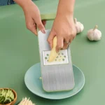 Multi-functional stainless steel grater and vegetable cutter, showing the various grating and slicing surfaces of the durable kitchen food preparation tool.